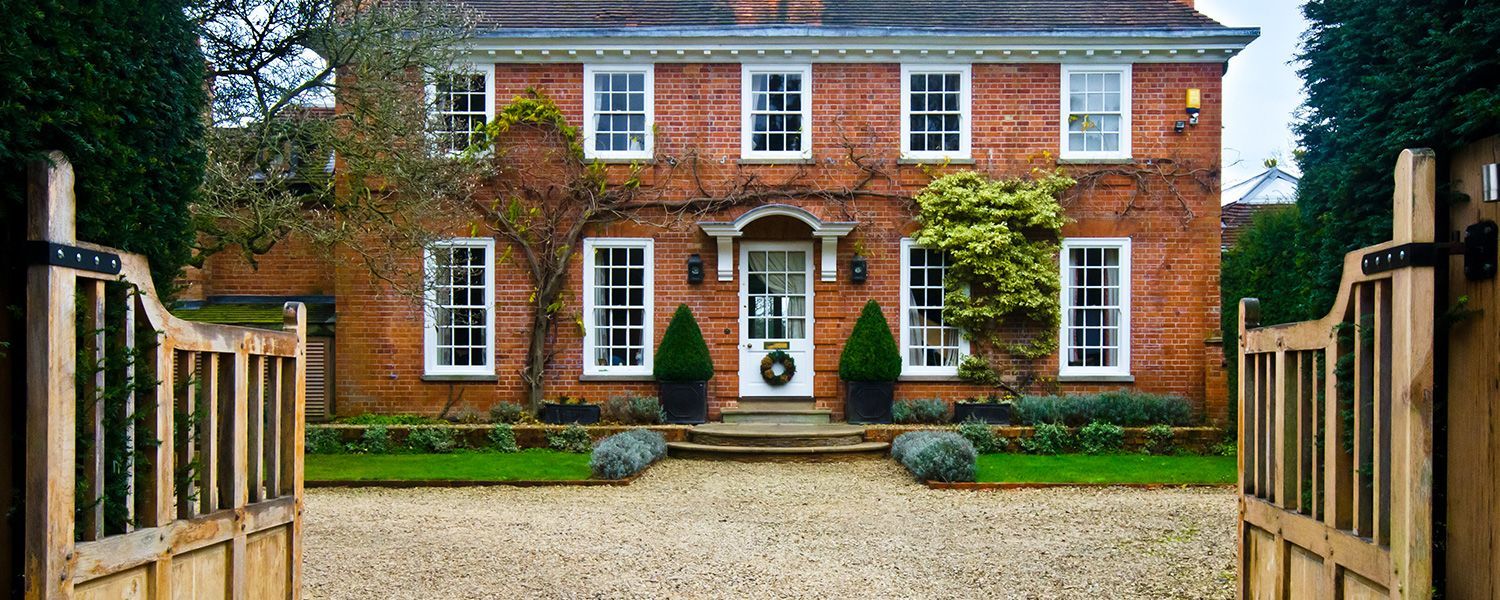 High Value Home Insurance: Open gates introducing an expensive house.