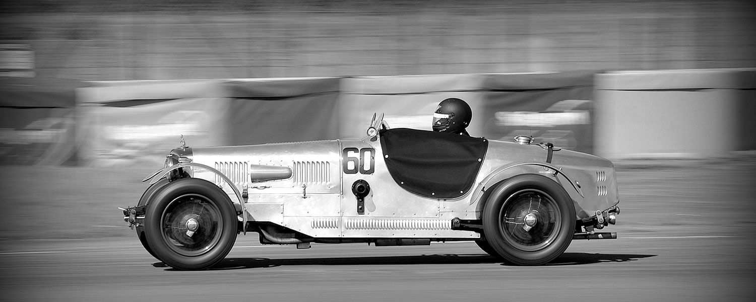 Vintage sports car club: A helmeted person driving a vintage sports car with the number 60 on it. 