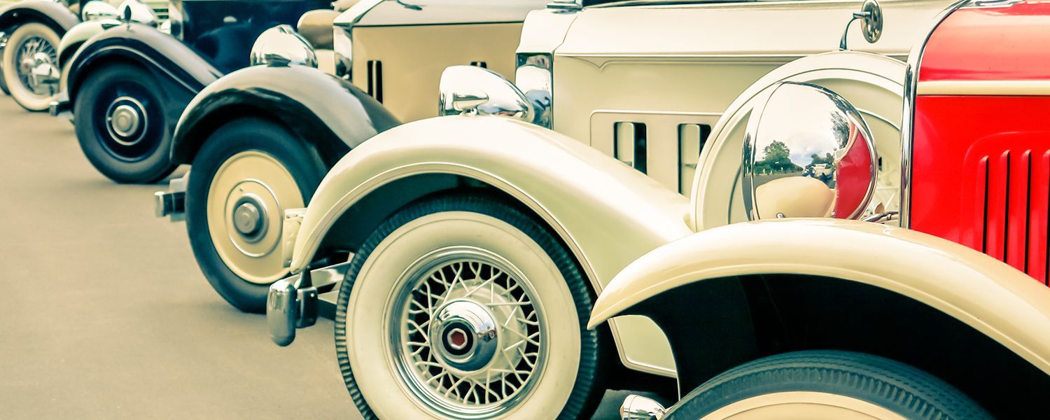 Vintage vehicles: Close-up of a row of vintage car's wheels.