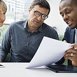 Case Study: an insurance broker showing a couple information on a piece of paper.