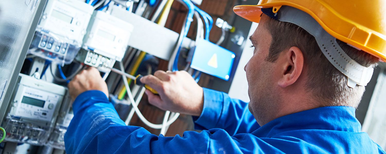 Electricians insurance: An electrician working within a fuse box.